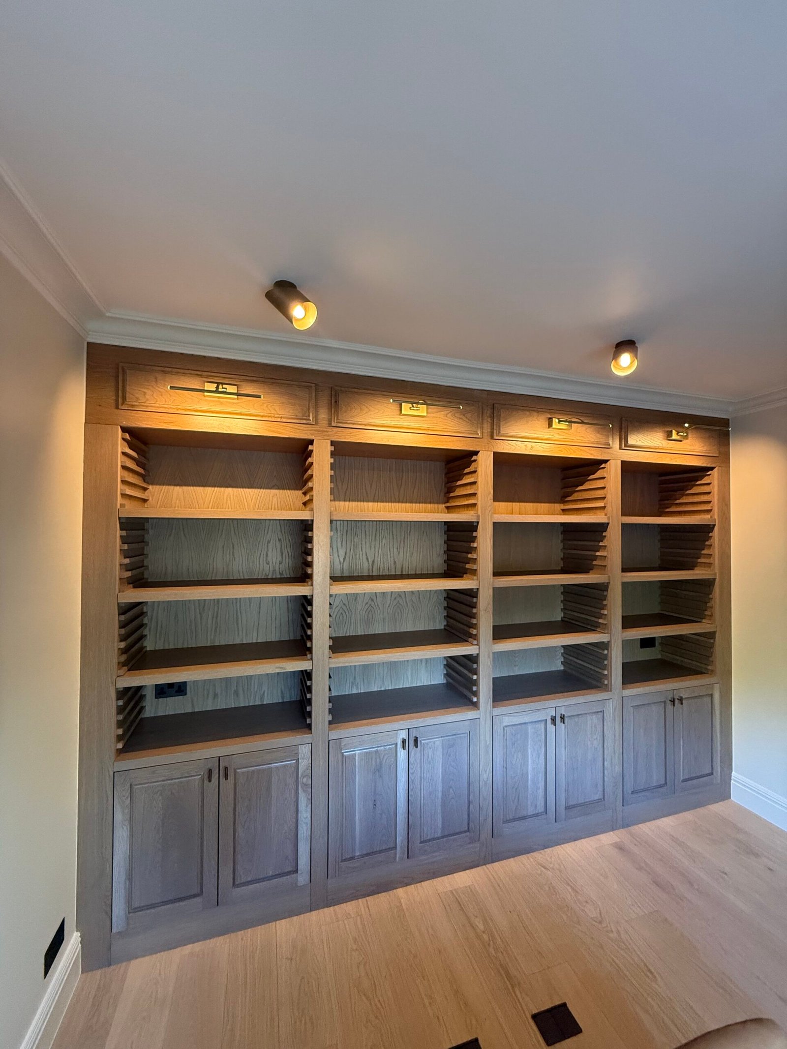 Custom oak bookcase with built-in lighting. | Julian Bespoke Interiors
